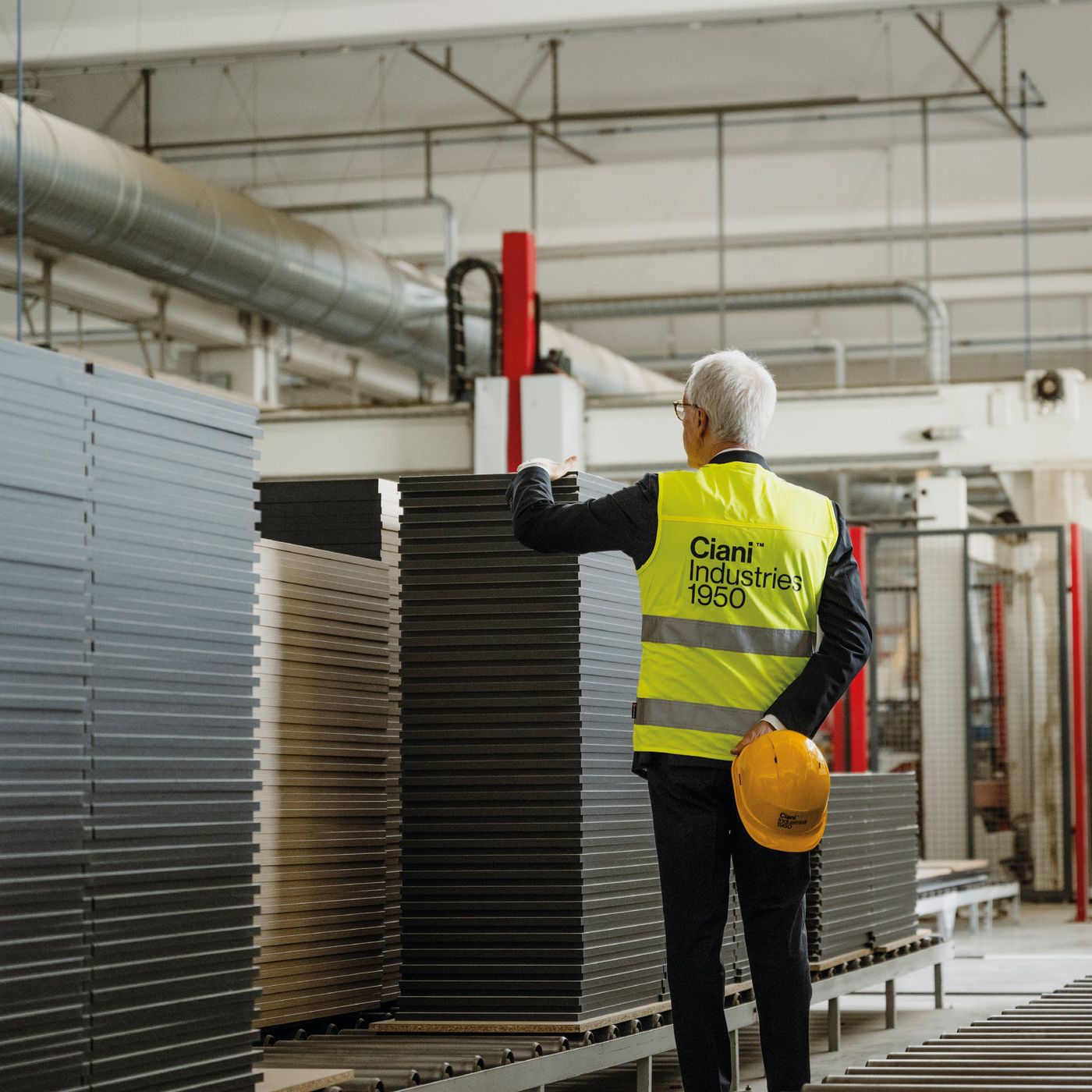 Craftsman guiding stacked timber panels through an Italian workshop