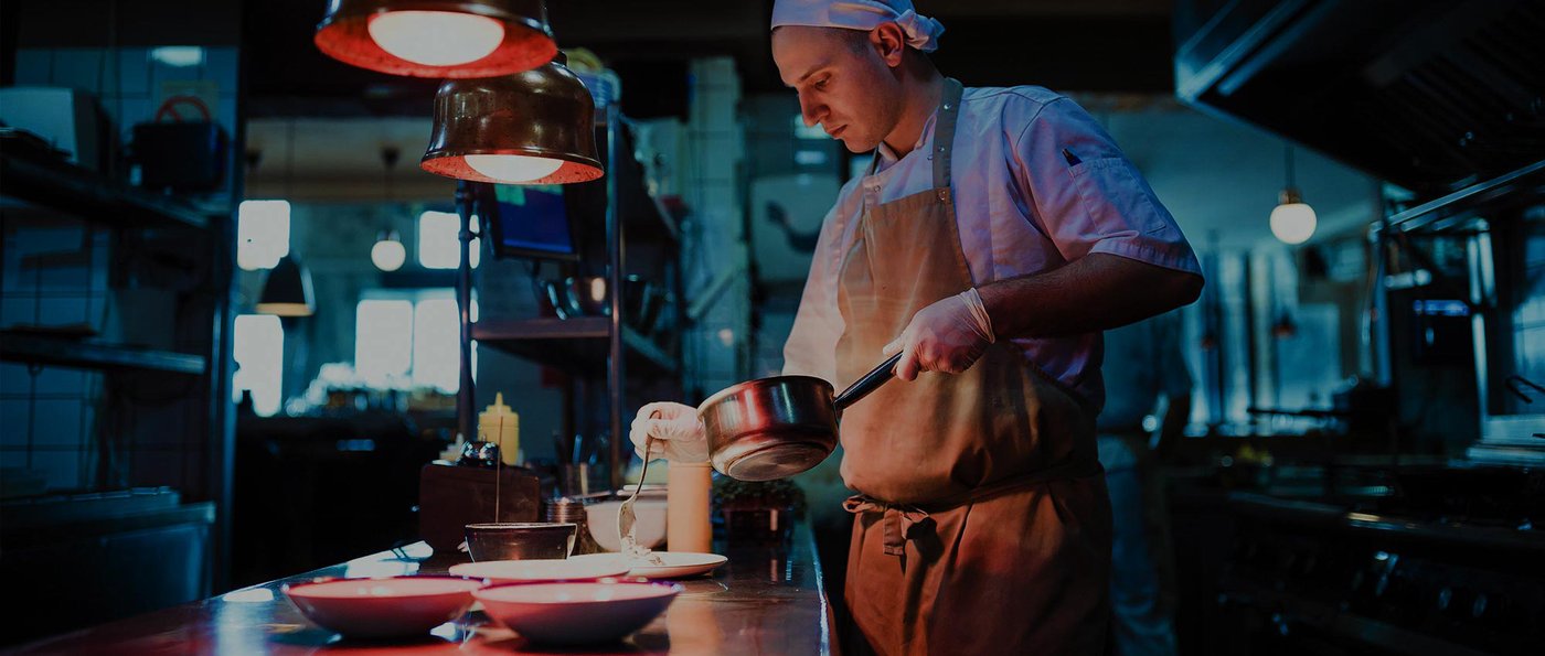 Chef plating a dish in a commercial kitchen